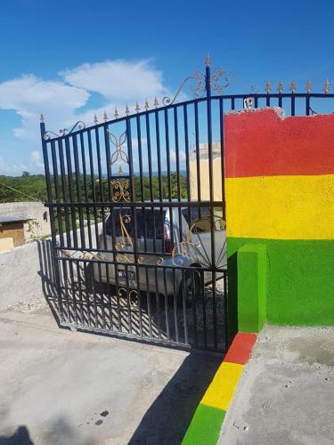 a metal gate with a rainbow colored wall at Solet's Paradise Negril in Negril