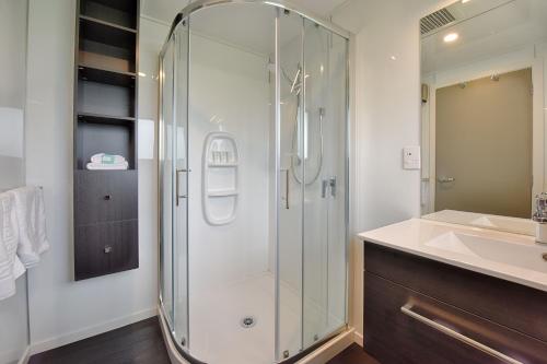 a bathroom with a glass shower and a sink at Croydon Lodge in Gore