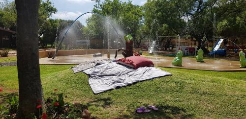 a park with a water park with a fountain at Die Plasie on-suite rooms in Hartbeespoort