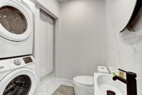 a bathroom with a washing machine and a sink at Burgundy Lofts - Marché Atwater in Montréal