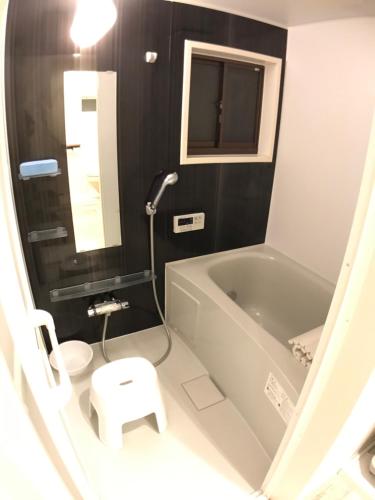 a bathroom with a tub and a toilet and a sink at MIC’s house haneda2 in Tokyo