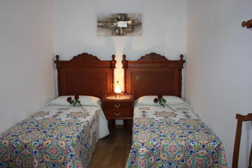 a room with two beds and a table with a lamp at Casa Luisita in Históric Center of Santa Lucía in Santa Lucía