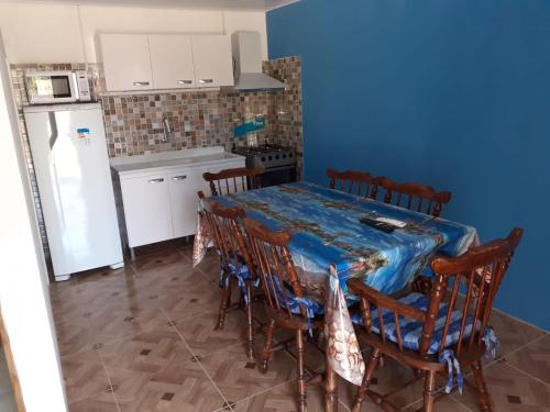 cocina con mesa, sillas y nevera en Complejo Celeste en Chuí