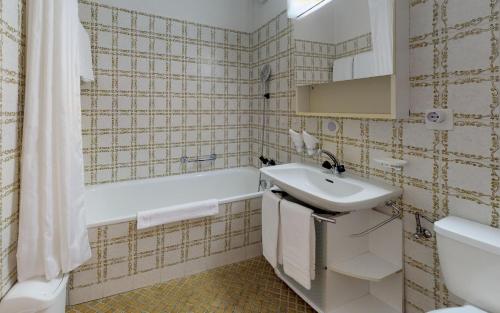 ein Badezimmer mit einem Waschbecken, einer Badewanne und einem WC in der Unterkunft Lac 16 in St. Moritz