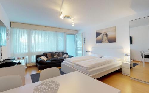 ein Wohnzimmer mit einem Bett und einem Sofa in der Unterkunft Lac 16 in St. Moritz