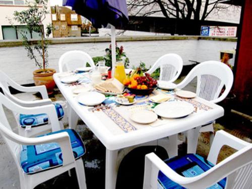 una mesa blanca con sillas blancas y un bol de fruta en St. George's Lodge en Kingston upon Thames