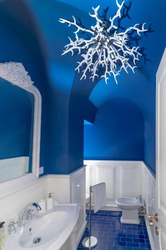 a blue bathroom with a toilet and a sink at Penthouse Donna Carmela in Anacapri