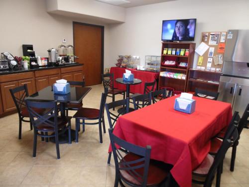 a restaurant with tables and chairs with red table cloth at Hotel Cotulla in Cotulla