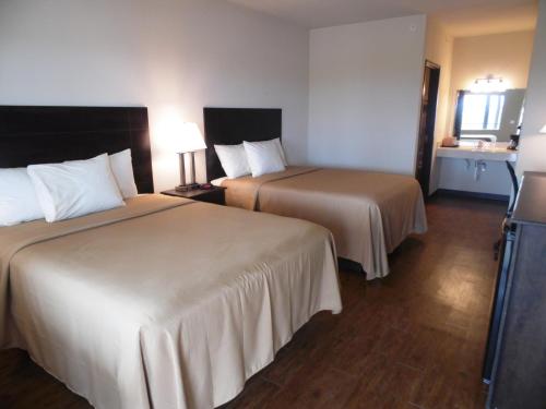 a hotel room with two beds and a television at Hotel Cotulla in Cotulla