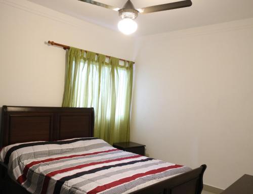 a bedroom with a bed with a striped blanket at Tu Segundo Hogar en Santiago, La Cuidad CORAZÓN in Santiago de los Caballeros