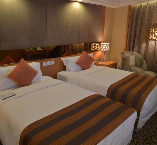 a hotel room with two beds and a chair at Park Plaza Beijing Science Park in Beijing