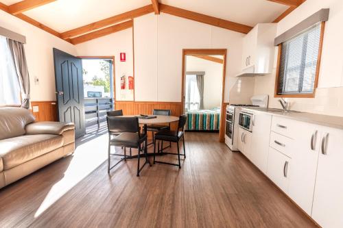 a kitchen and living room with a table and chairs at Barwon River Holiday Park in Geelong