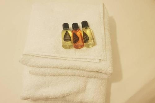 three nail polish bottles sitting on top of a towel at Garland Modern House With Parking & Garden Croydon in Croydon
