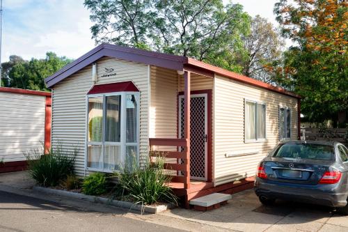 a small house with a car parked in front of it at Barwon River Holiday Park in Geelong