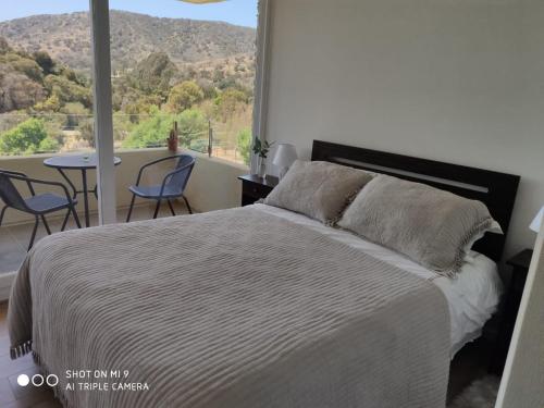 a bedroom with a bed and a table with chairs at Departamento Papudo in Papudo