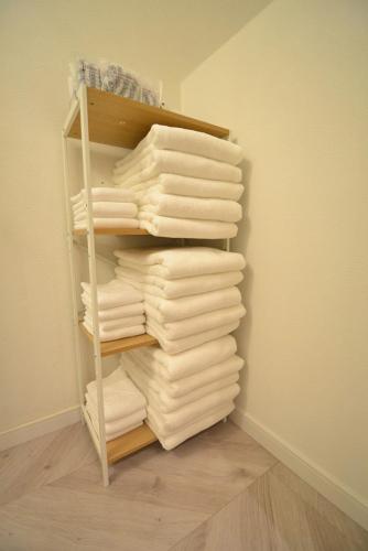 a stack of towels on a shelf in a closet at 出来島サクラハウス一戸建 Sakura House Terrace 阪神出来島駅徒歩2分 USJ近く Dekijima in Osaka