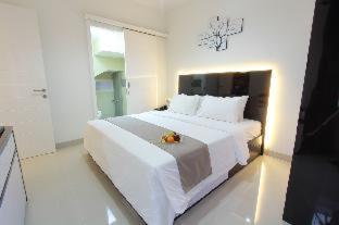 a large white bedroom with a large white bed at R Hotel Rancamaya in Bogor