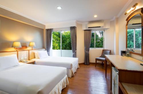 アランヤプラテートにあるStation ONE Hotel - Aranyapratethのベッド2台とデスクが備わるホテルルームです。