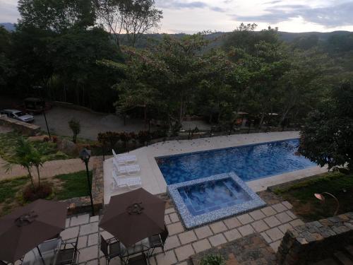 an overhead view of a swimming pool with umbrellas at Hotel Casas de Campo El Ciruelo in San Gil