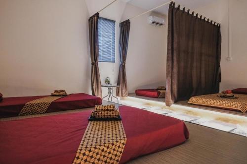 a room with three beds and a window at RedDoorz Apartment @ Batam Centre 3 in Batam Center