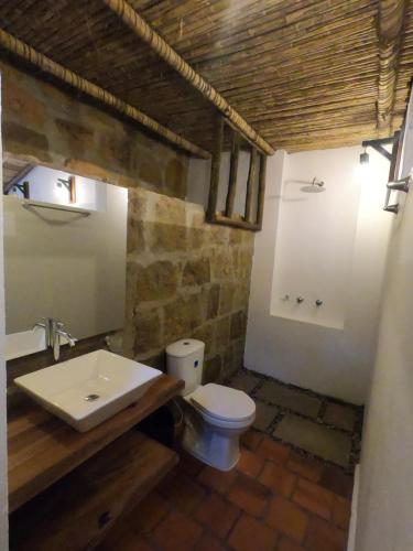 a bathroom with a white toilet and a sink at Hotel Casas de Campo El Ciruelo in San Gil