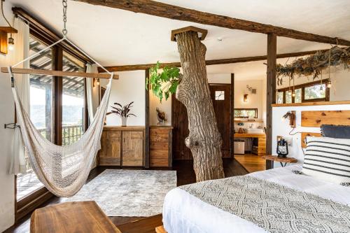 a bedroom with a hammock and a tree at Tree-house Hotel Morinosubako in Nakijin