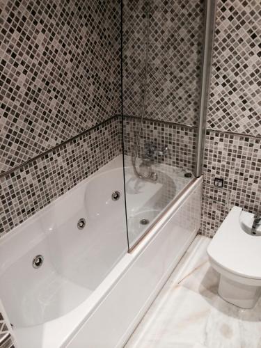 a bathroom with a tub and a toilet at Aparthotel del Golf in Sant Cugat del Vallès