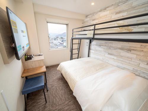 ein Schlafzimmer mit einem Etagenbett und einem Flachbild-TV in der Unterkunft Super Hotel Echizen Takefu in Echizen