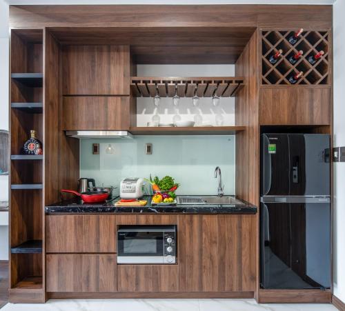 una cucina con armadi in legno e frigorifero di Sharon Hotel and Apartment a Da Nang
