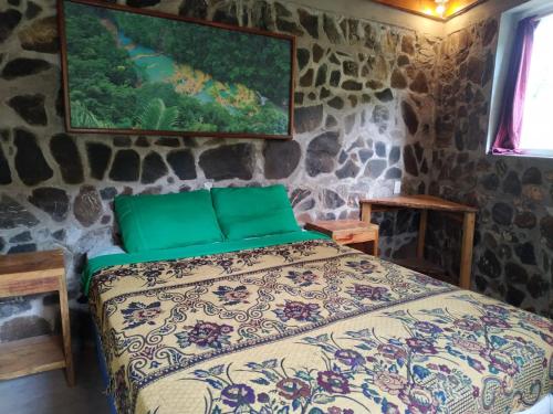 a bedroom with a bed in a stone wall at Ch'i Bocól Community Hostel in Lanquín