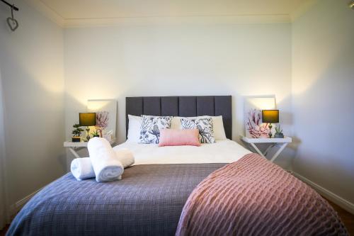um quarto com uma cama grande com almofadas em Dell-Lee Cottage em Broke