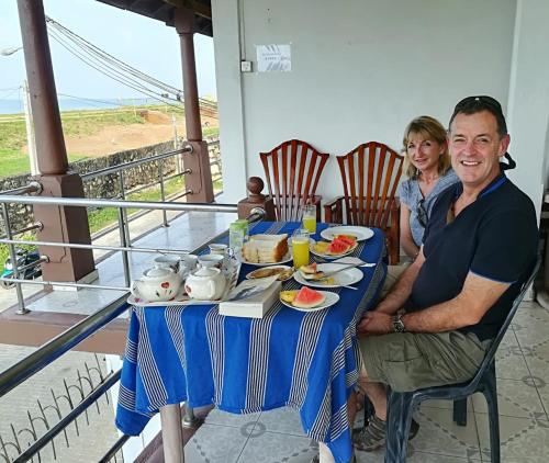 a man and woman sitting at a table with plates of food at Rampart View Guesthouse in Galle