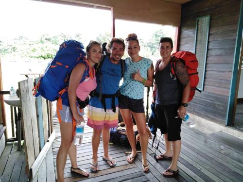 a group of people with backpacks on a porch at AA Homestay in Mulu