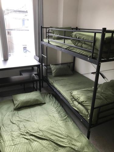 two bunk beds in a room with a bed at Joinus Ise Apartment in Ise