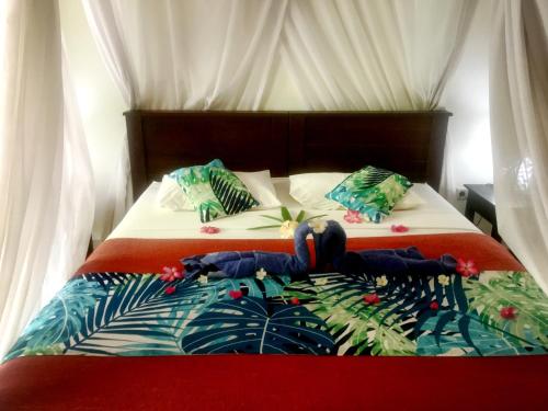 a bedroom with two beds with red and white at Mango Moon in Pemuteran
