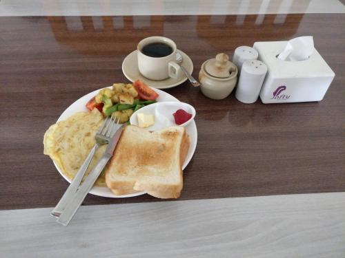 a plate of food with toast and a cup of coffee at Hotel hornbill in Sauraha