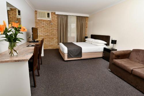 a hotel room with a bed and a desk at Burke and Wills Motor Inn in Moree