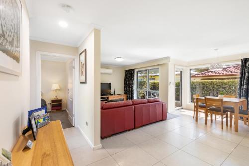 a living room with a red couch and a table at City One Apartment in Mount Gambier