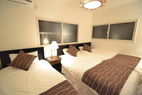 a hotel room with two beds and two windows at 出来島サクラハウス一戸建 Sakura House Terrace 阪神出来島駅徒歩2分 USJ近く Dekijima in Osaka