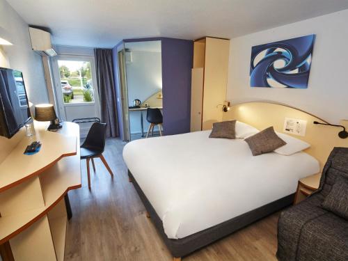 a hotel room with a large bed and a chair at Kyriad Direct Bron Lyon Eurexpo in Bron