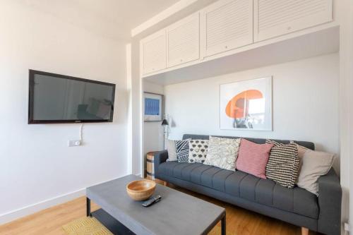 a living room with a couch and a tv at GuestReady - 1BR Flat Ideally Located In Zone 2 Fits 3 in London