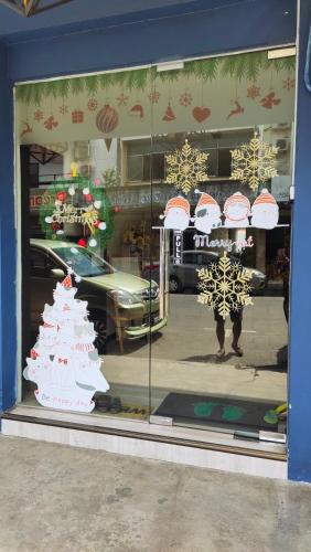 a window of a store with a christmas tree in it at Kuree Hut in Semporna
