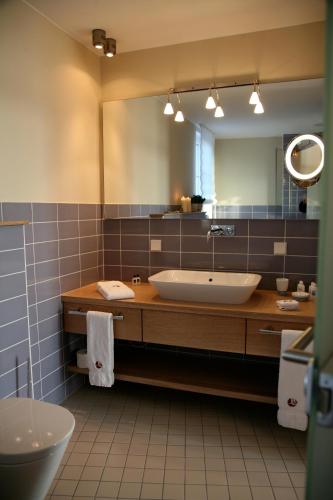 a bathroom with a sink and a large mirror at Strand-Hotel Seenelke in Wilhelmshaven