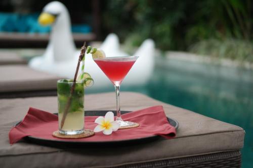 a drink in a glass on a table with a napkin at Chandra Bali Villas in Seminyak