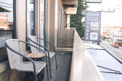 un balcón con sillas y una señal en un edificio en Chula Premium Homes, en Ban Chang