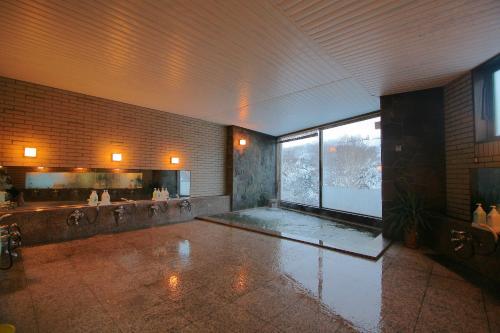 ein großes Badezimmer mit großem Fenster in einem Gebäude in der Unterkunft Hotel Araragi in Yamanouchi