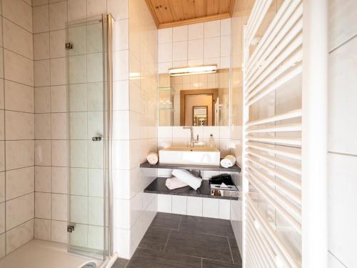 bagno con lavandino e specchio di Gästehaus Gratlspitz ad Alpbach