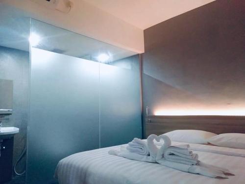 two swans shaped towels sitting on top of a bed at Hotel Marina Airport Semarang in Semarang