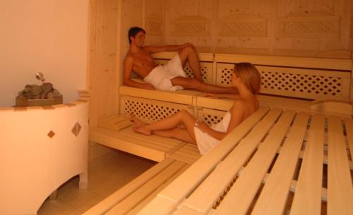 a man and a woman sitting on bunk beds at Hotel Neuwirt in Ramsau am Dachstein