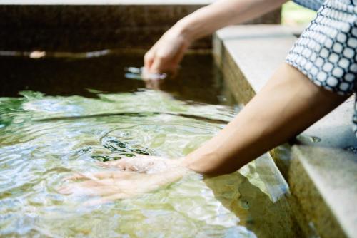 a person is standing in a pool of water at 久住高原 赤川温泉スパージュ-Spaju in Taketa